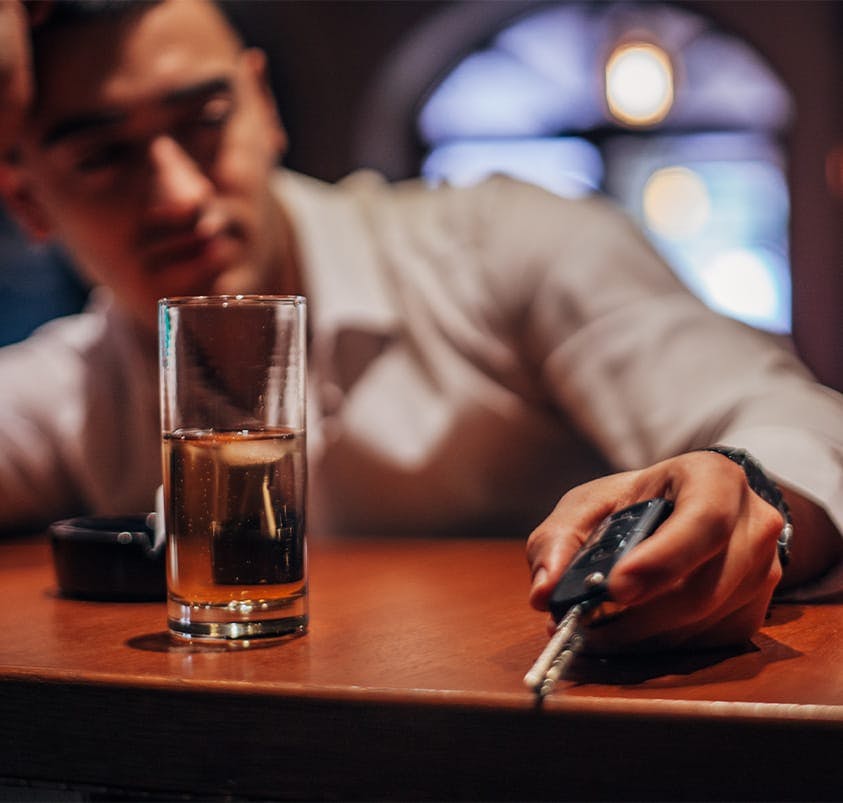 person at bar holding keys