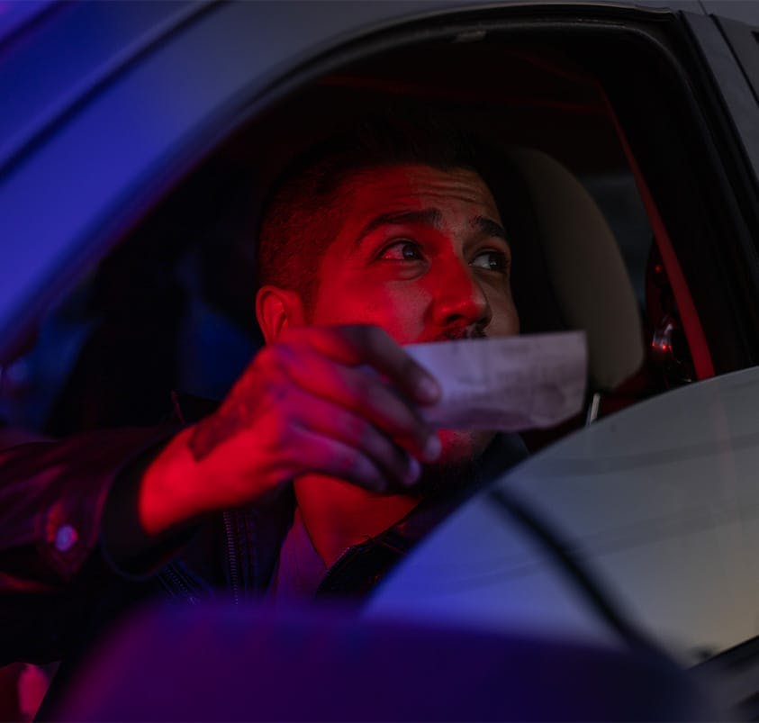 person handing their ID to a cop