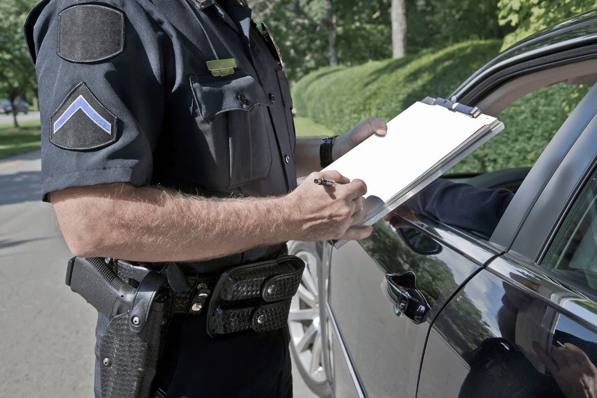Cop giving a ticket to someone on the side of the road