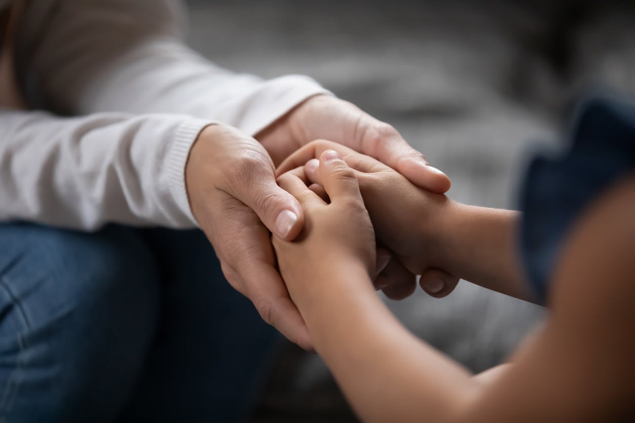 Person holding child's hand