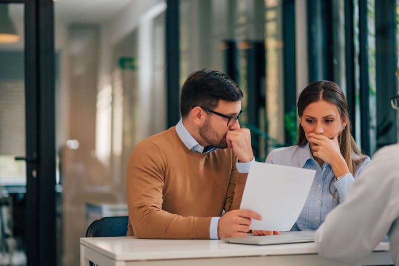 A stressed couple looking at a document