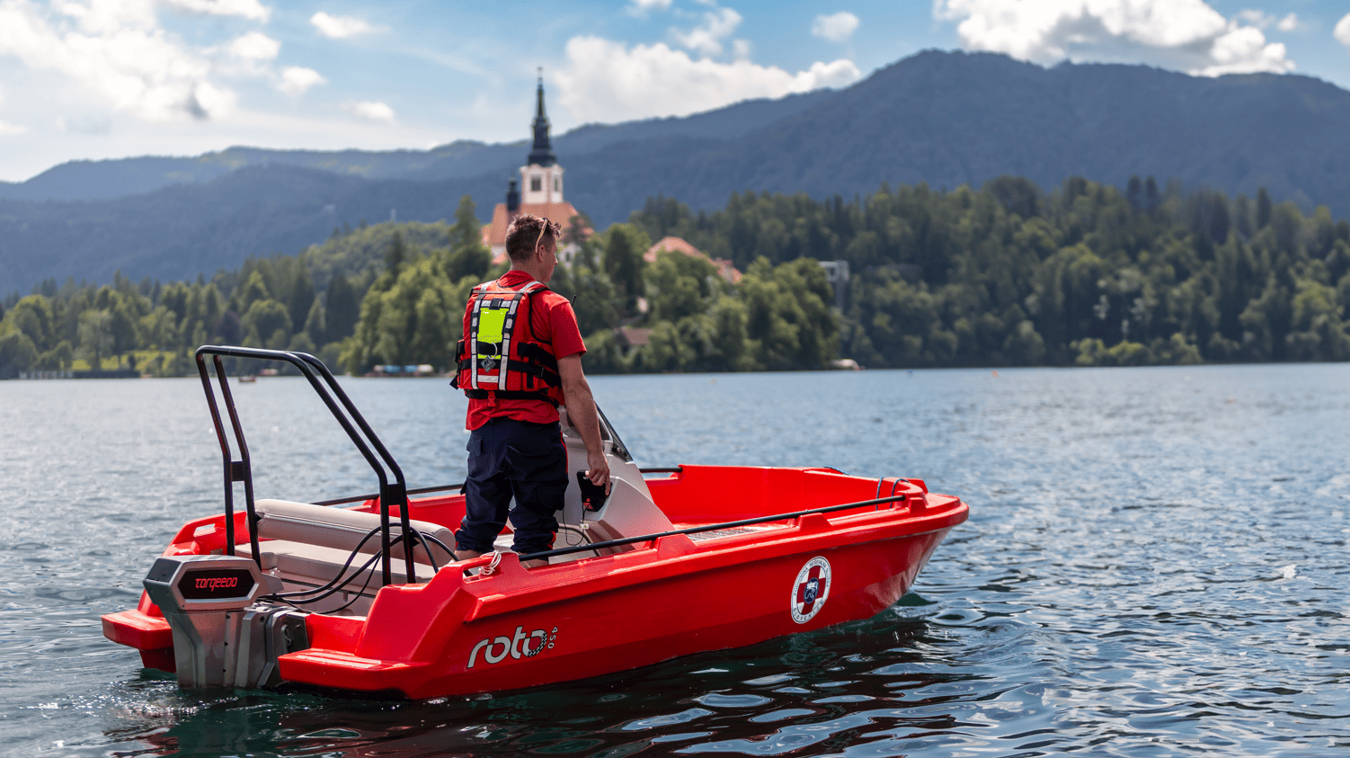 Rescuer patrolling Lake Bled in a polyethylene coastline rescue boat.