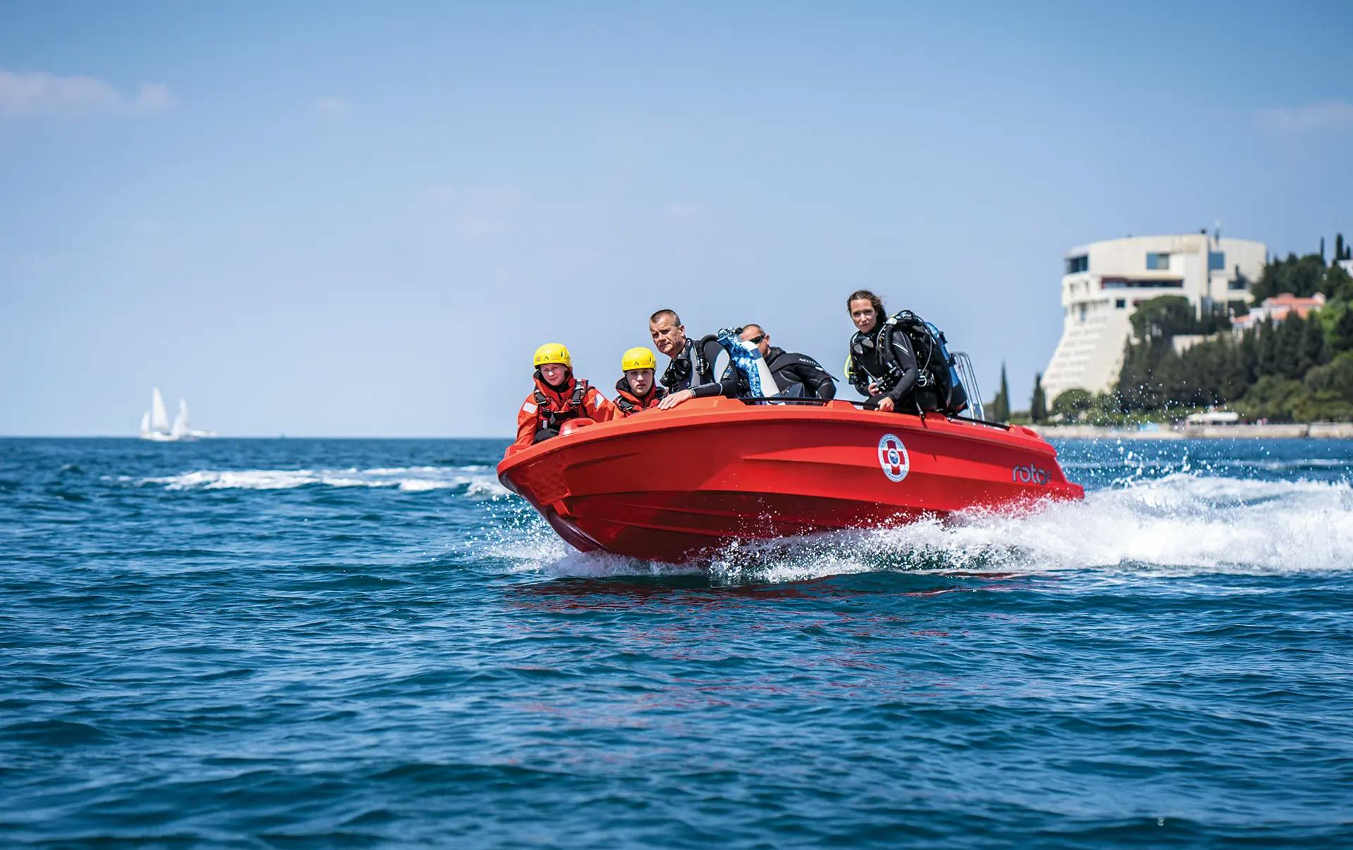Roto Nautica Hydra 450 rescue boat cutting through waves with a team of rescuers on a high-speed sea rescue mission.