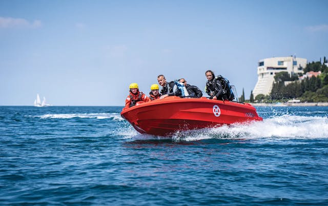 Roto Nautica Hydra 450 rescue boat cutting through waves with a team of rescuers on a high-speed sea rescue mission.