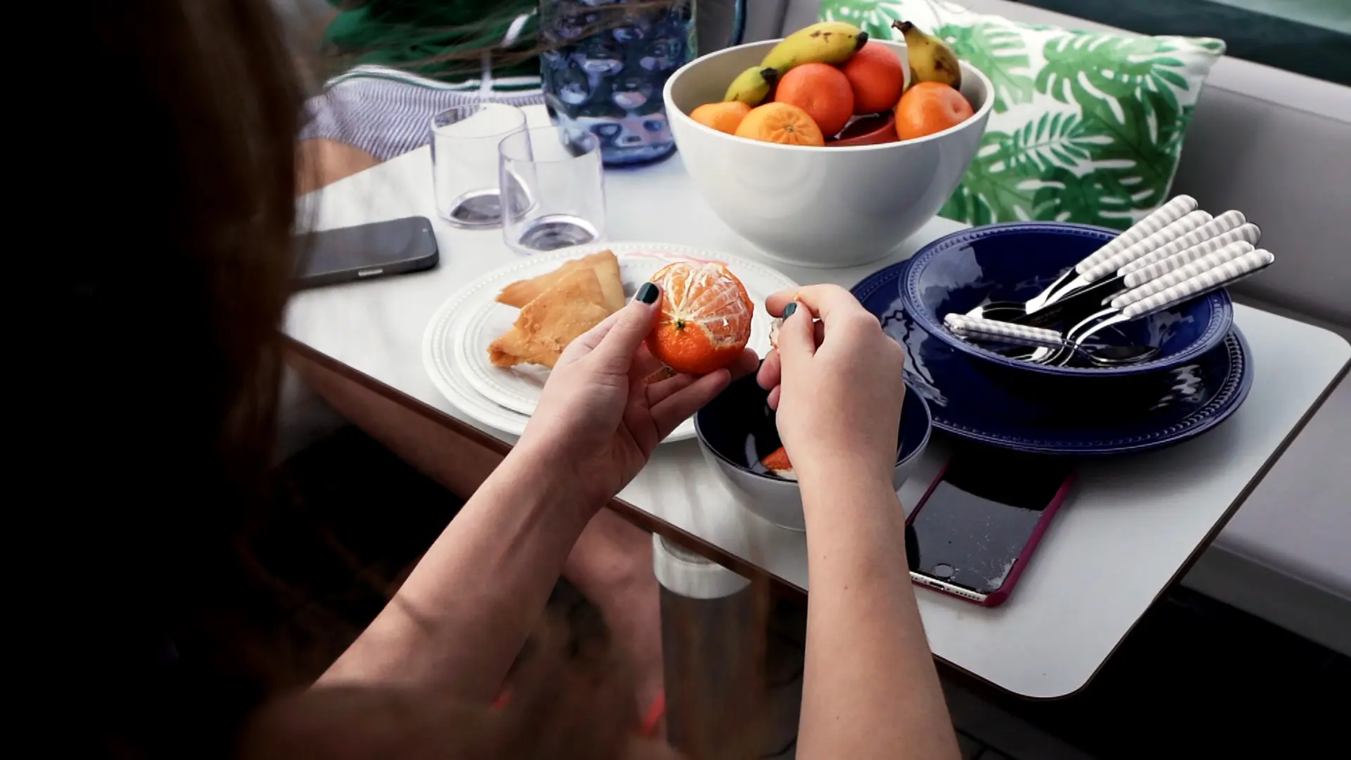 Woman peeling oranges on deck during a quiet boat trip.