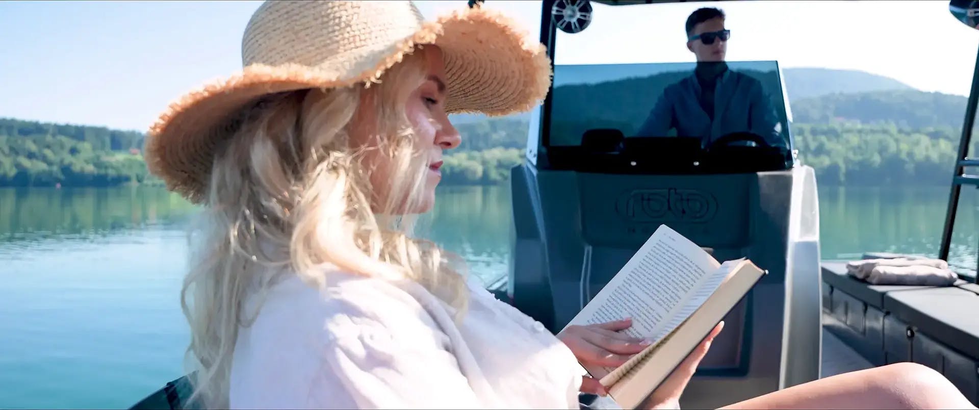 Young woman reading a book aboard the Korkyra 650 catamaran boat.