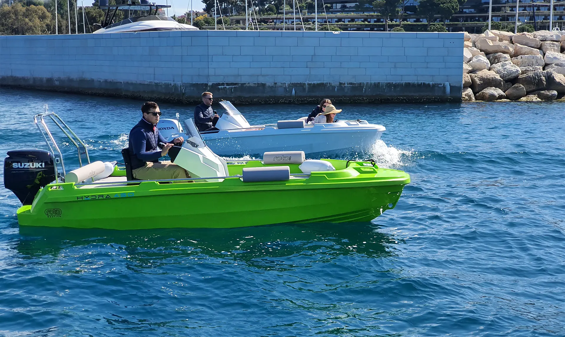 Two rotomolded boats moving slowly through the harbour.