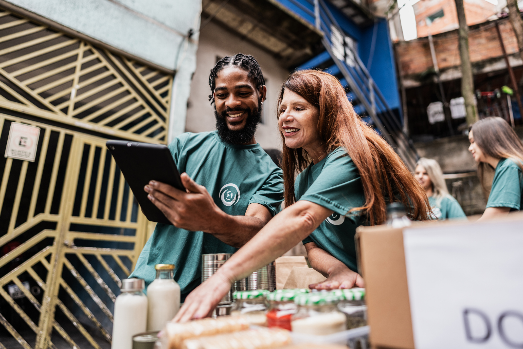 Volunteers Working at a Food Bank on a Tablet