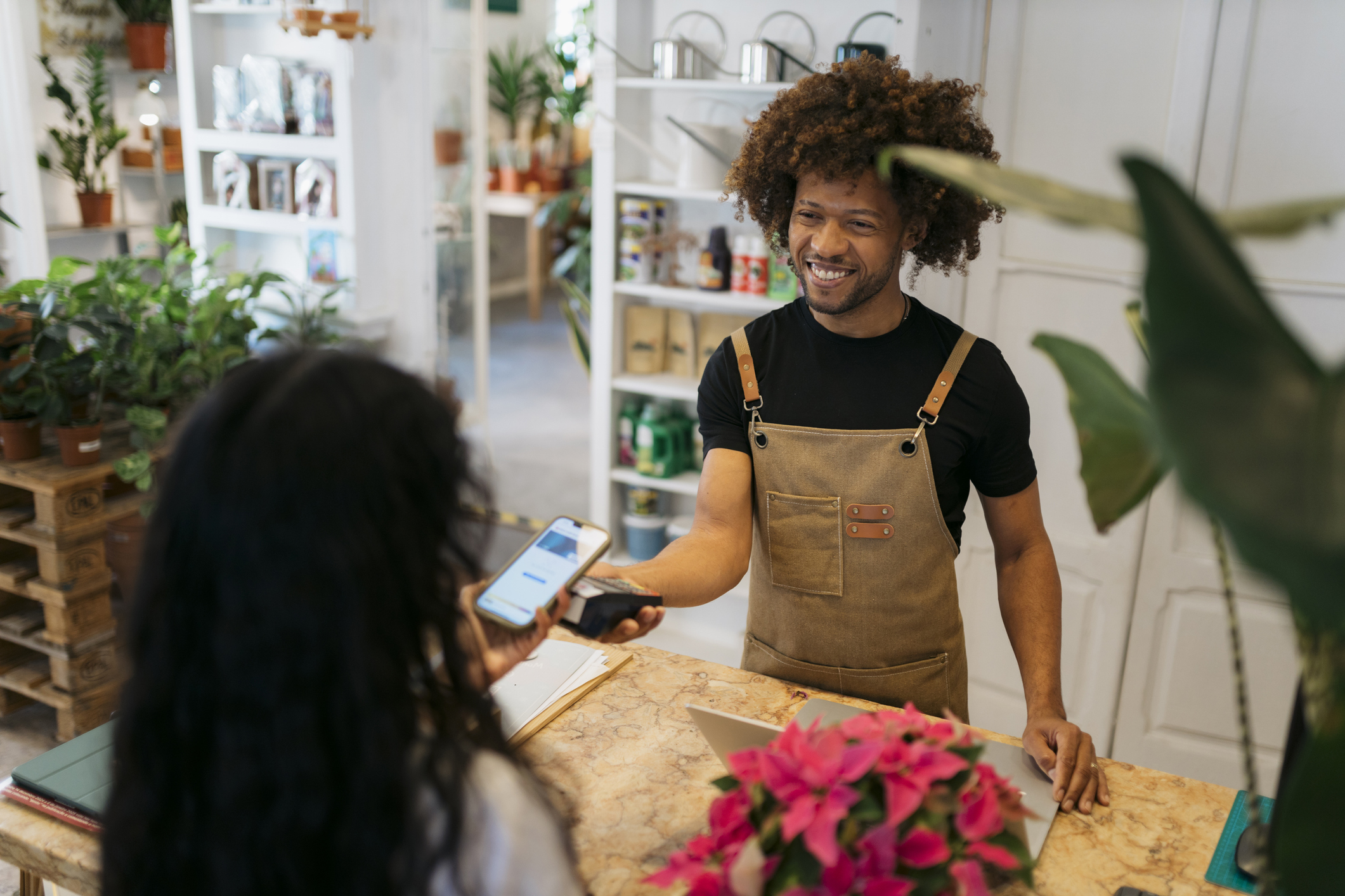 Business Owner Using a POS device to Checkout Customers