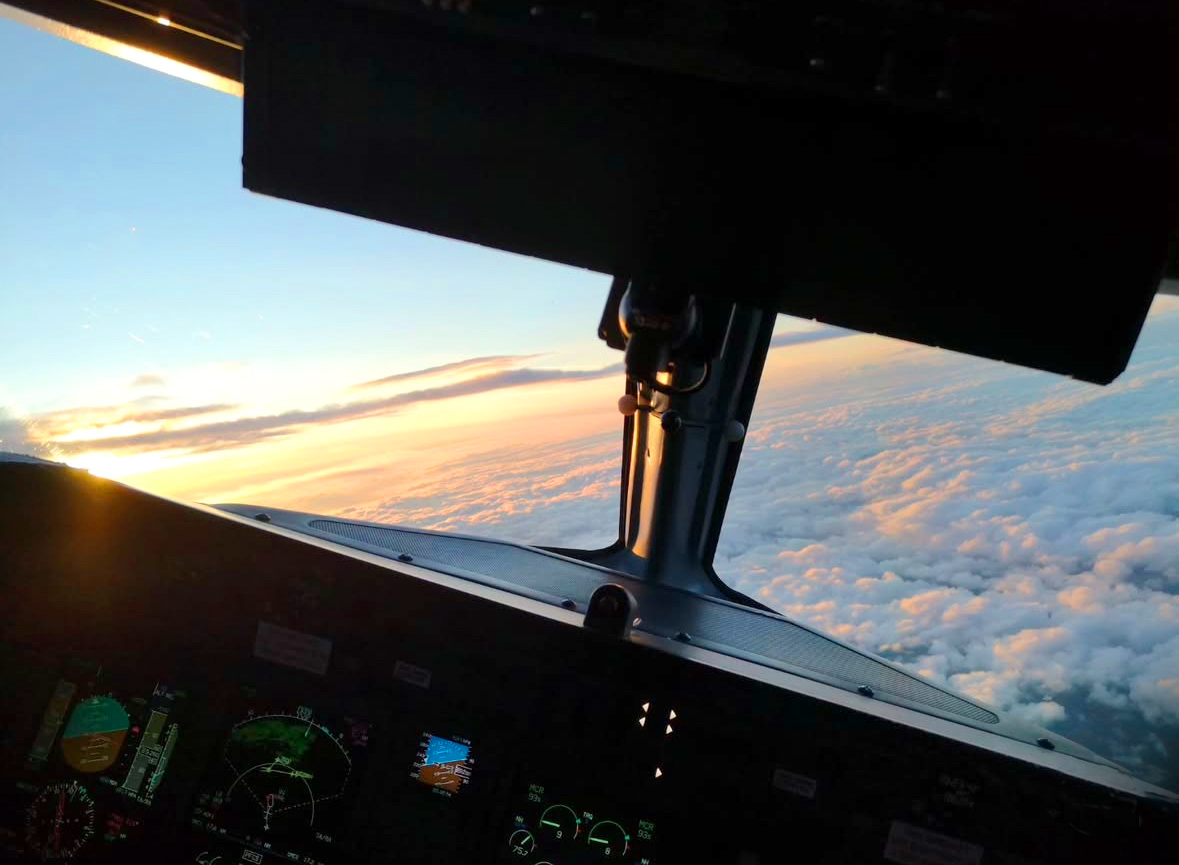 View out of a plane cockpit above the clouds