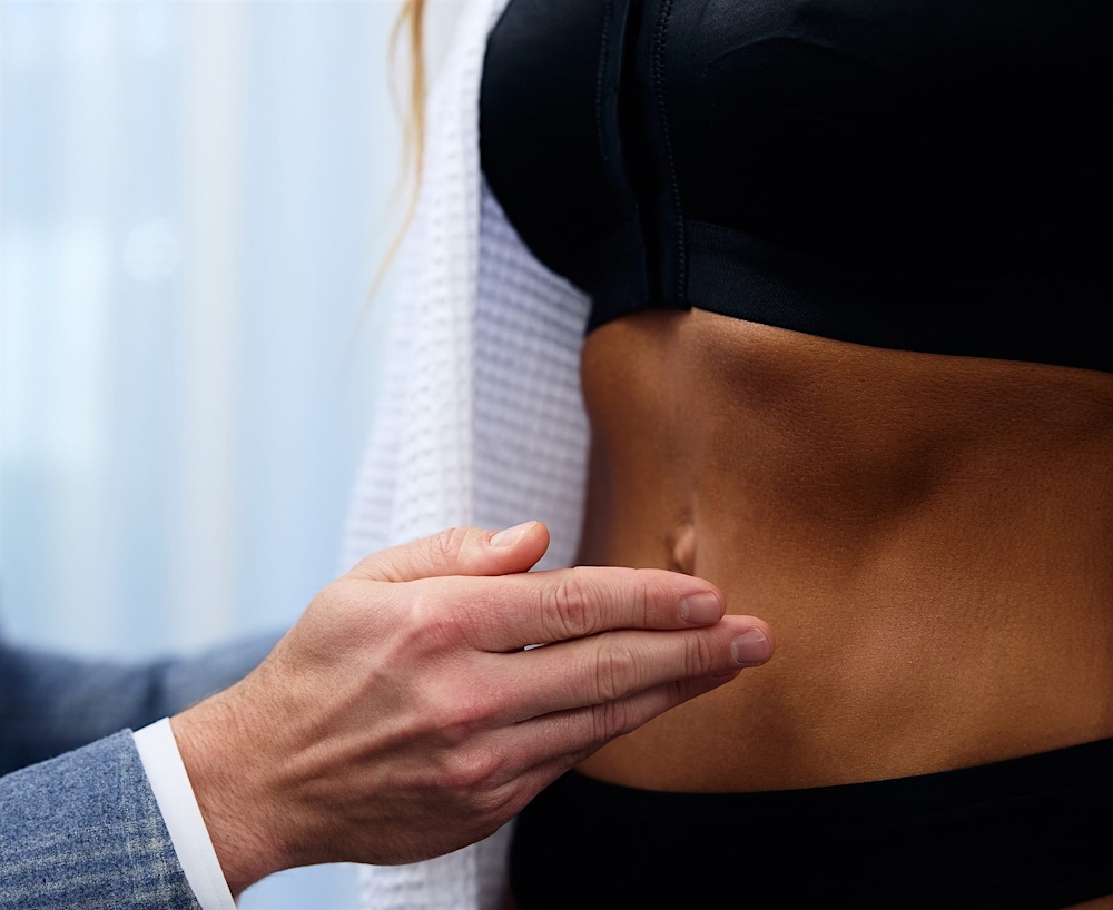 Dr Unger gesturing to patient's stomach