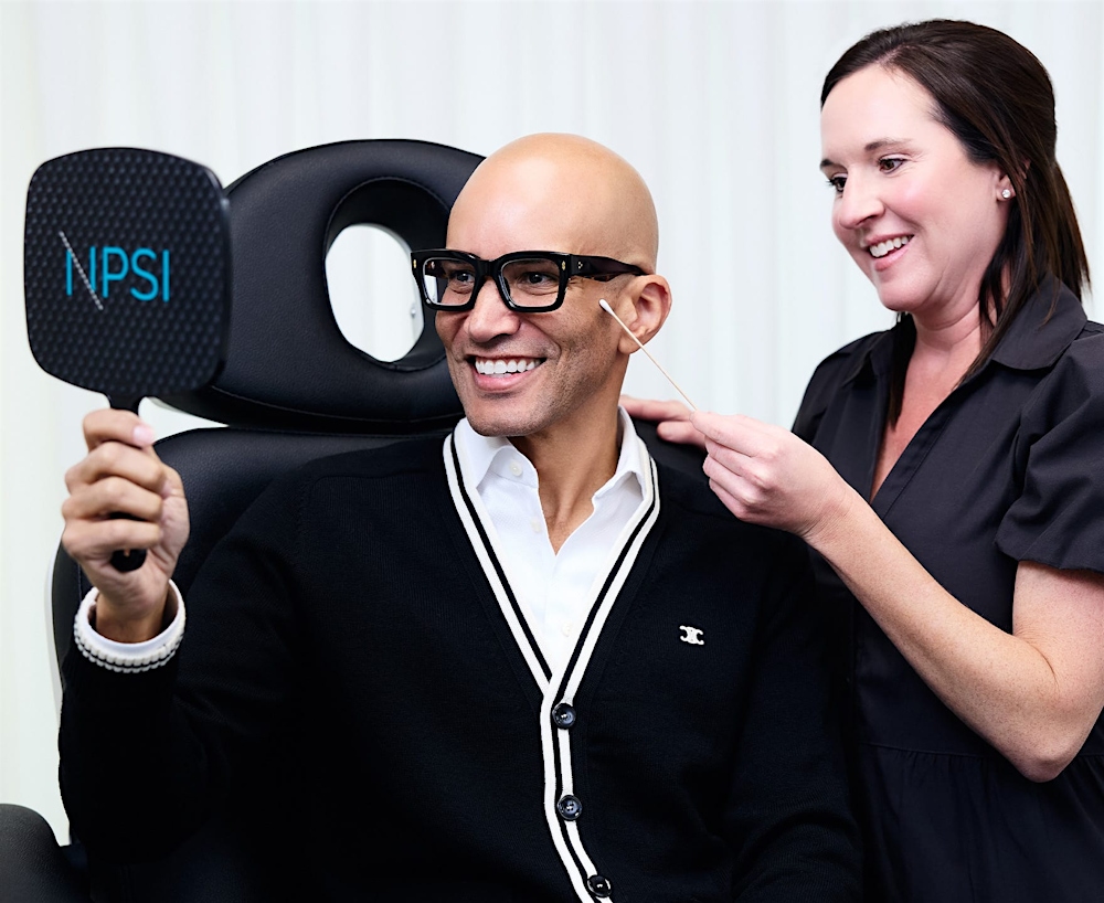 man smiling into hand mirror