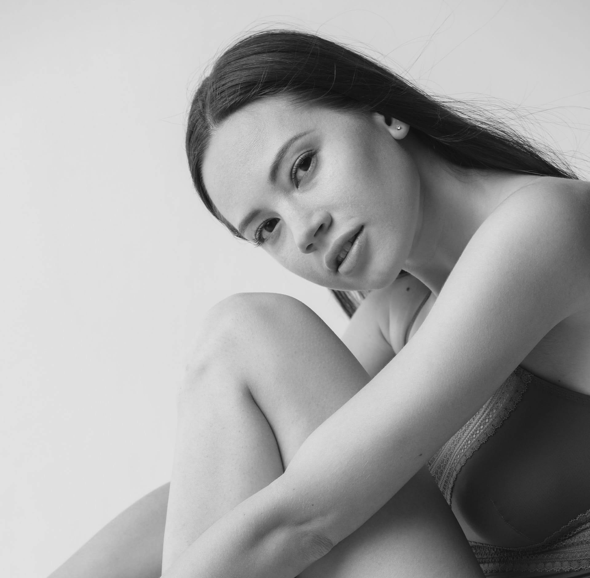 Woman posing with arms around leg