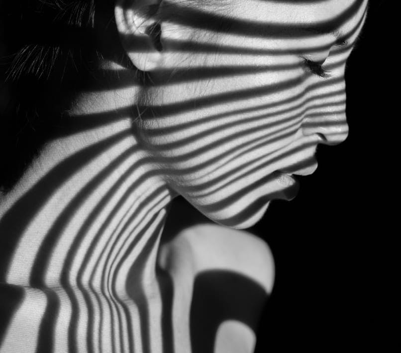 black and white image of a woman with shadow lines on her face
