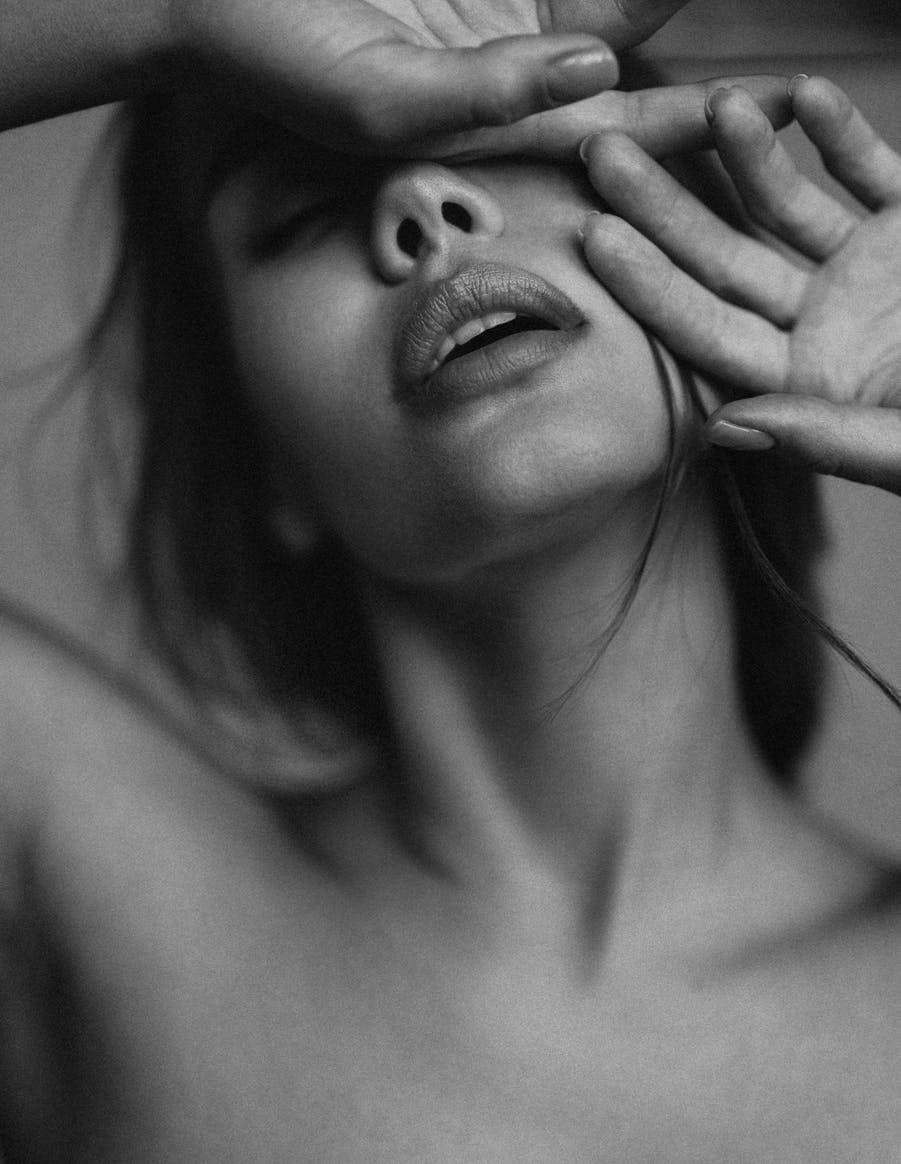 Black and white photo of beautiful woman's face with hands up to cheek and forehead. Perfect Skin emulates potential results of dermal fillers in Nashville.