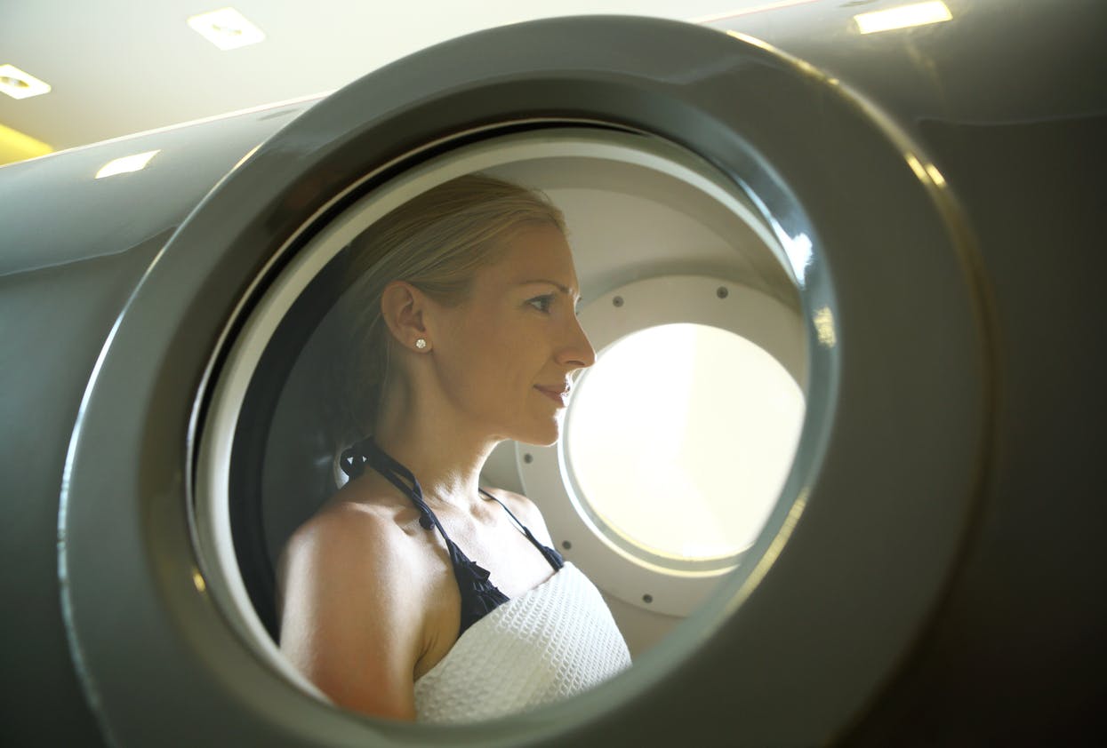 Woman in hyperbaric chamber during treatment.