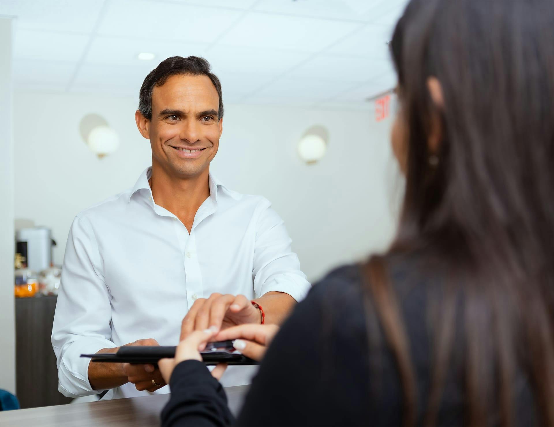man grabbing ipad from receptionist
