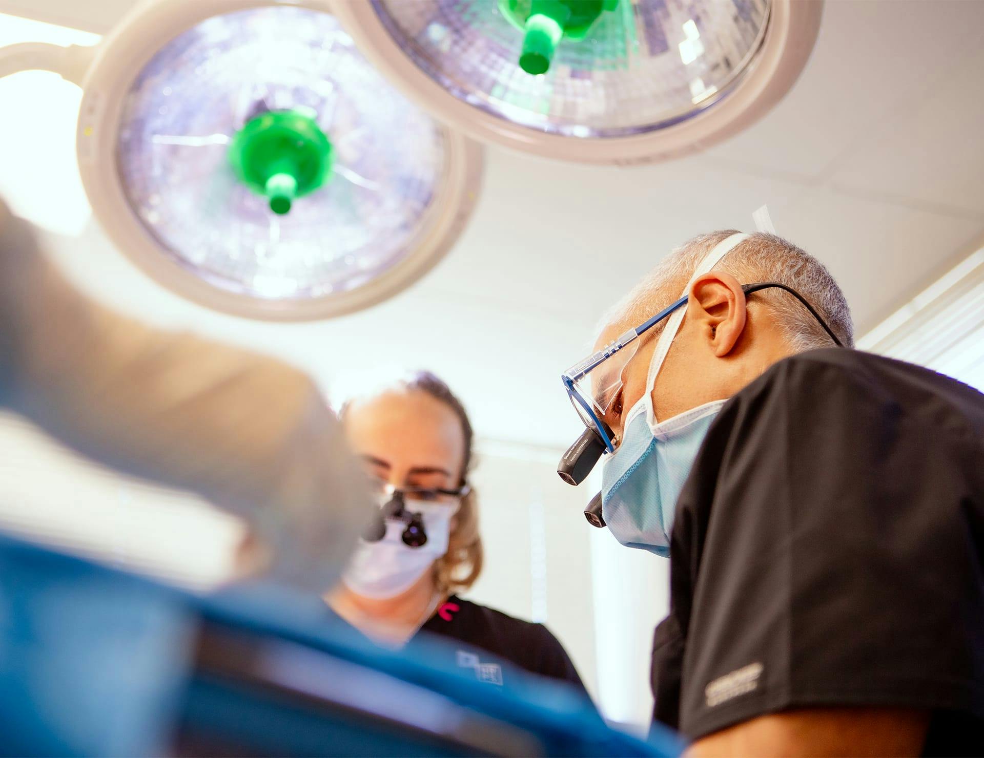 downview of doctors in uniform doing hair restoration procedure