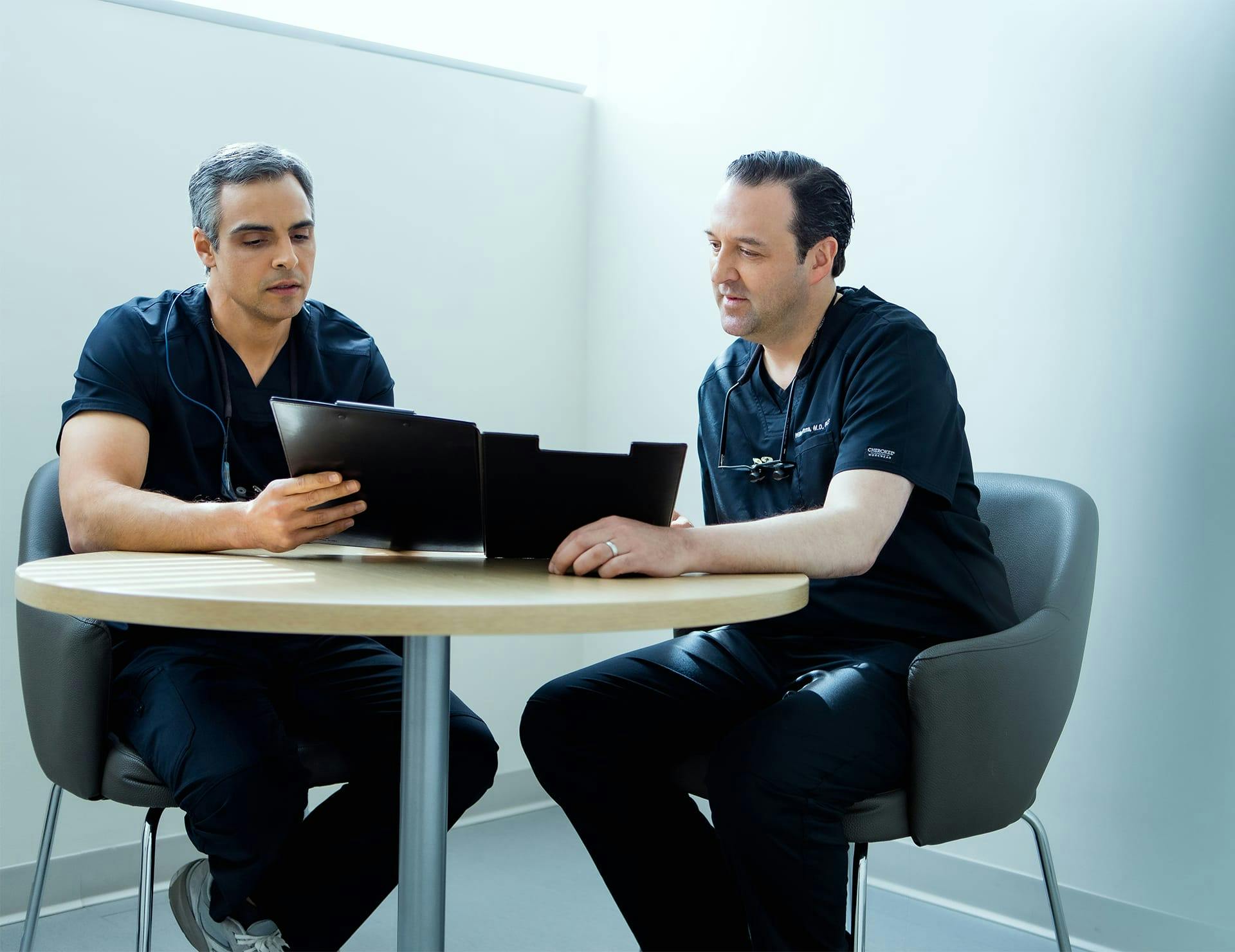 2 staff members sitting together at table looking at ipad