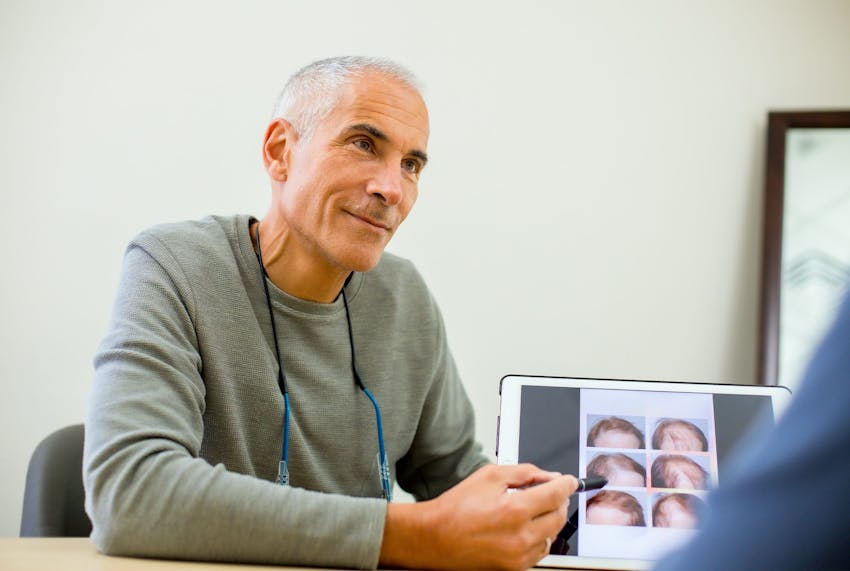 Jeffrey sitting and pointing to ipad thats showing before and afters