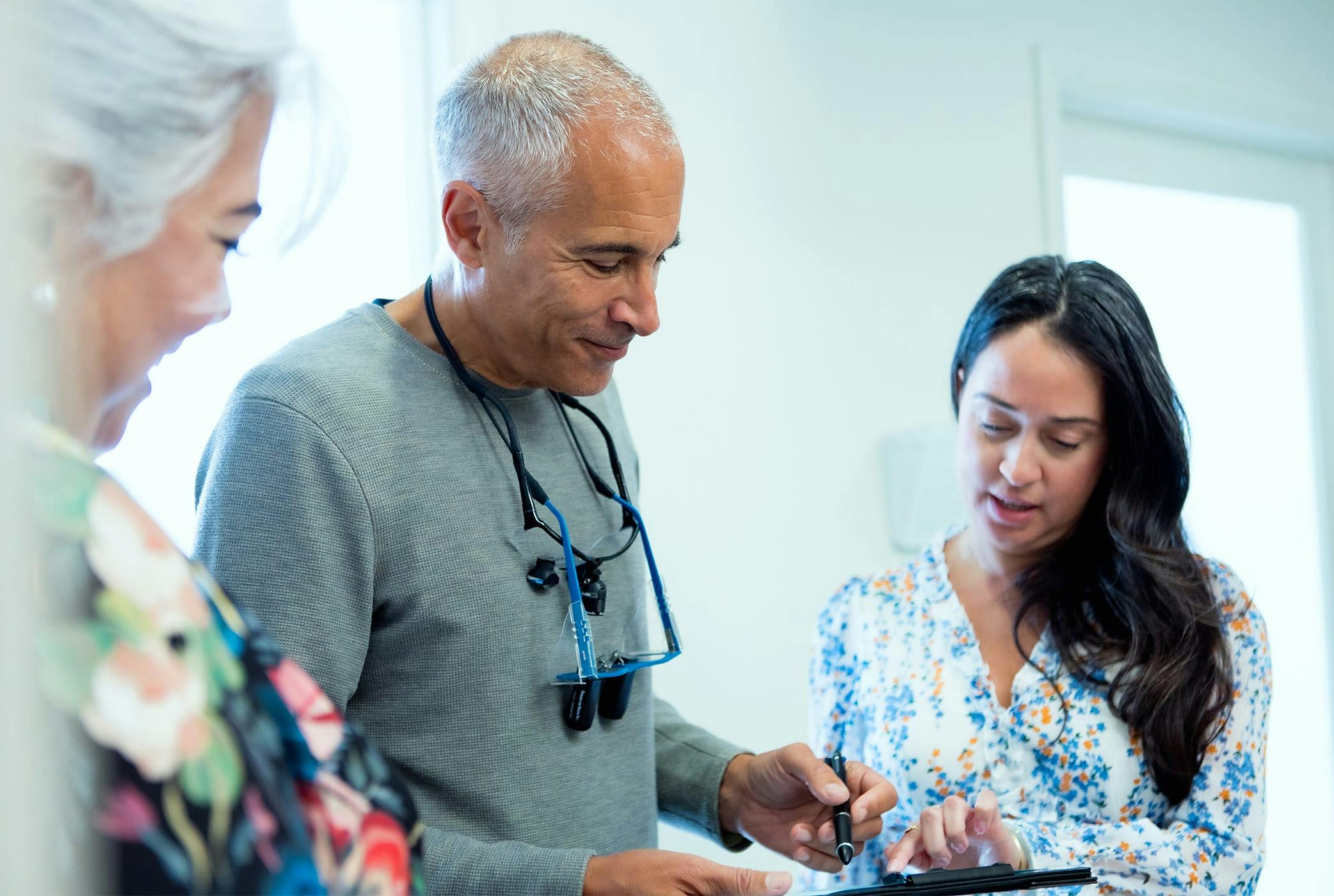 Jeffrey looking at form with 2 ladies next to him