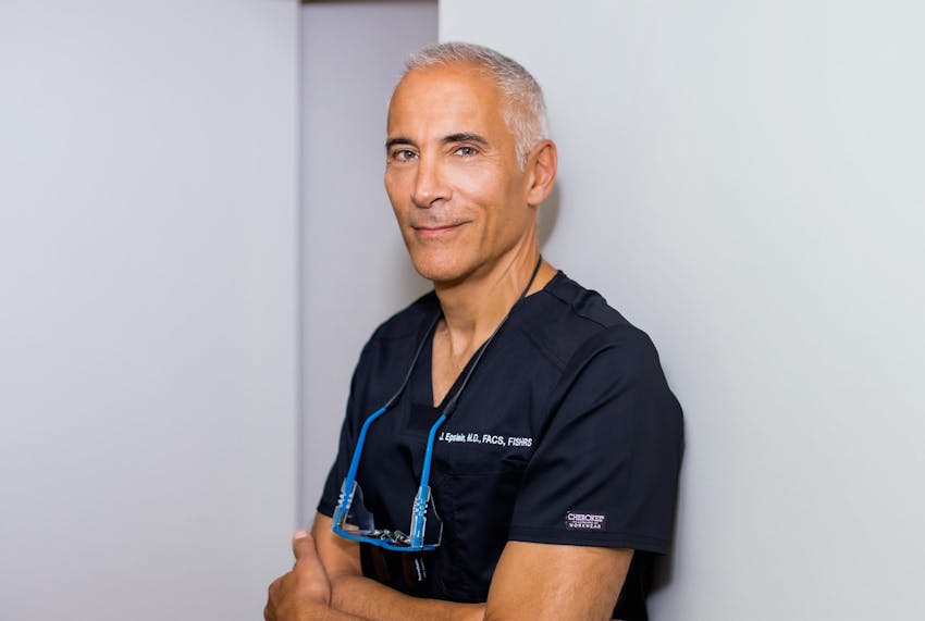 Jeffrey Epstein in uniform with arms crossed