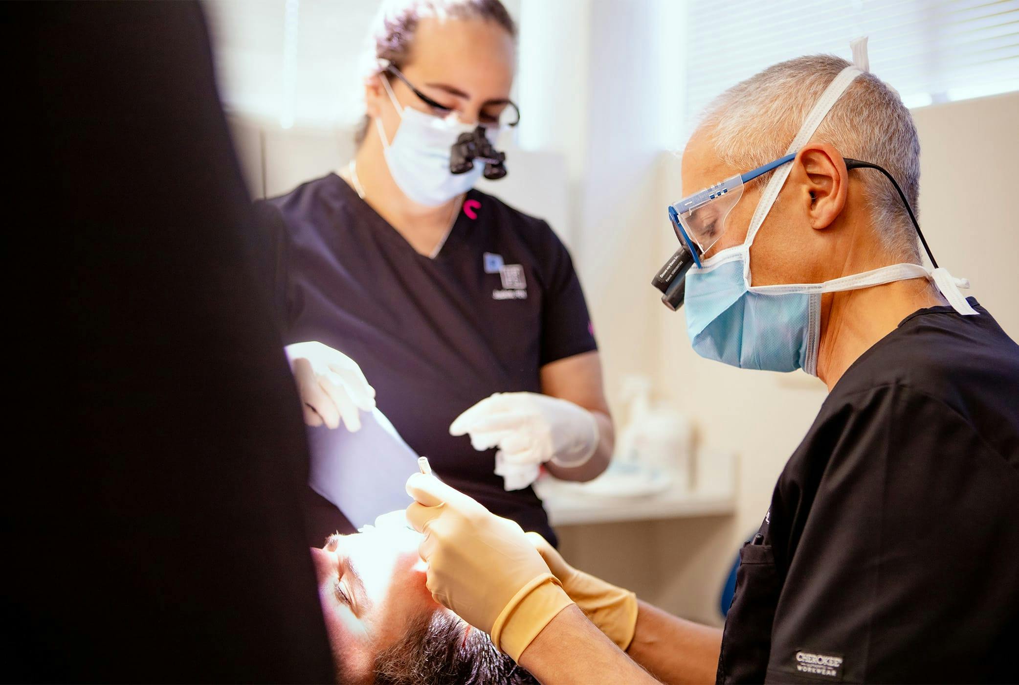 doctors doing hair follicle extraction on client
