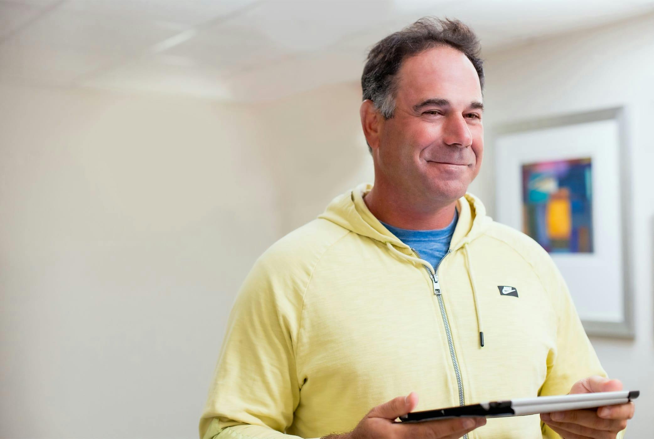 male client in yellow jacket holding ipad