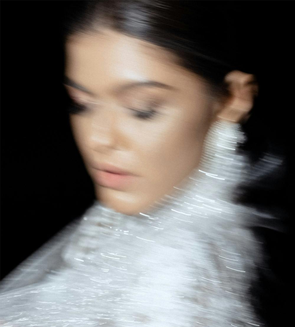 blurry image of a woman wearing a white glittery outfit