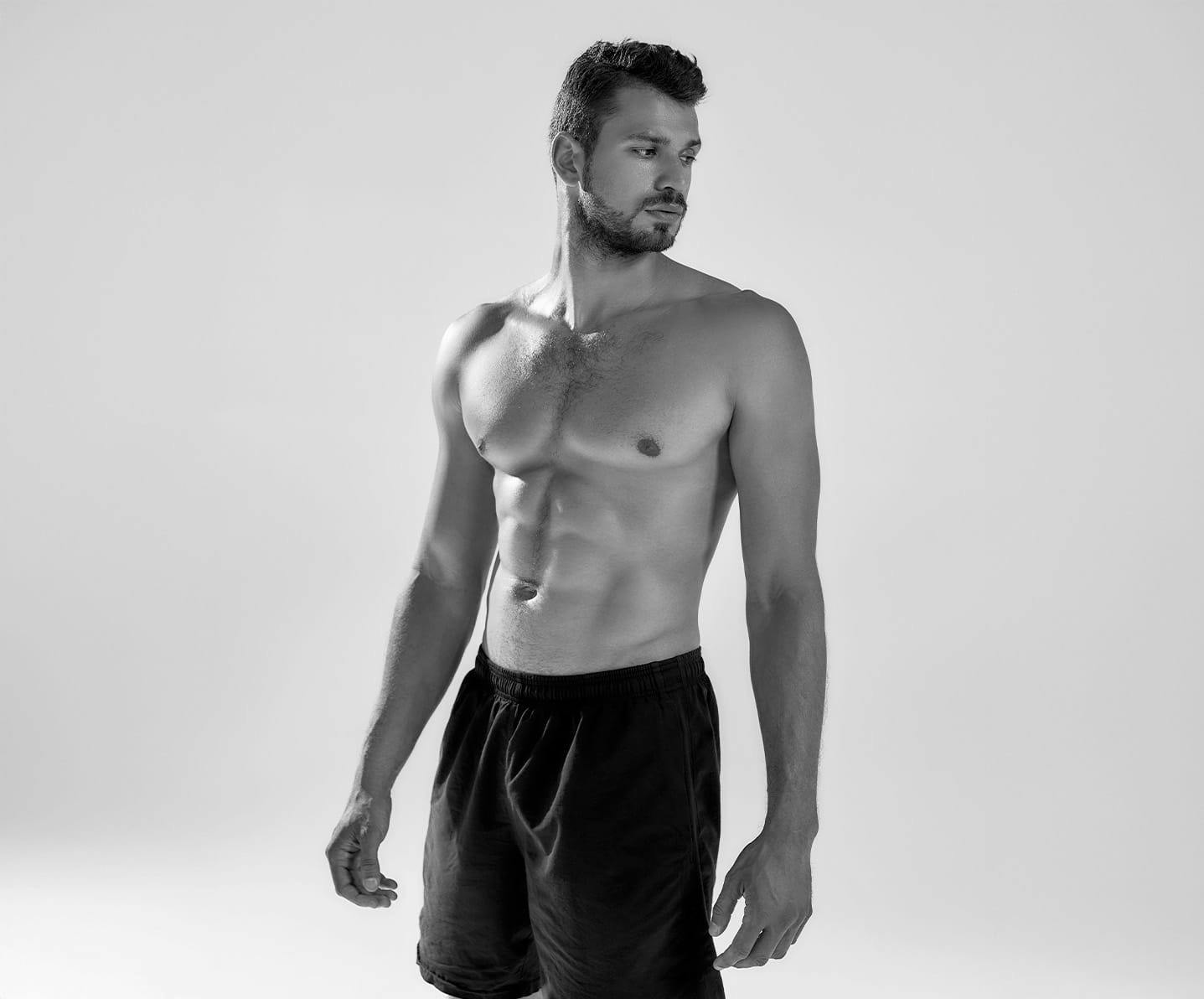 shirtless man looking over his shoulder