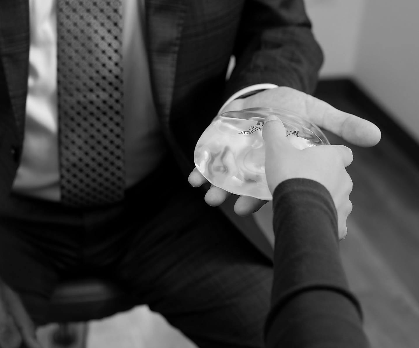 Dr. Fazilat passing a breast implant to patient