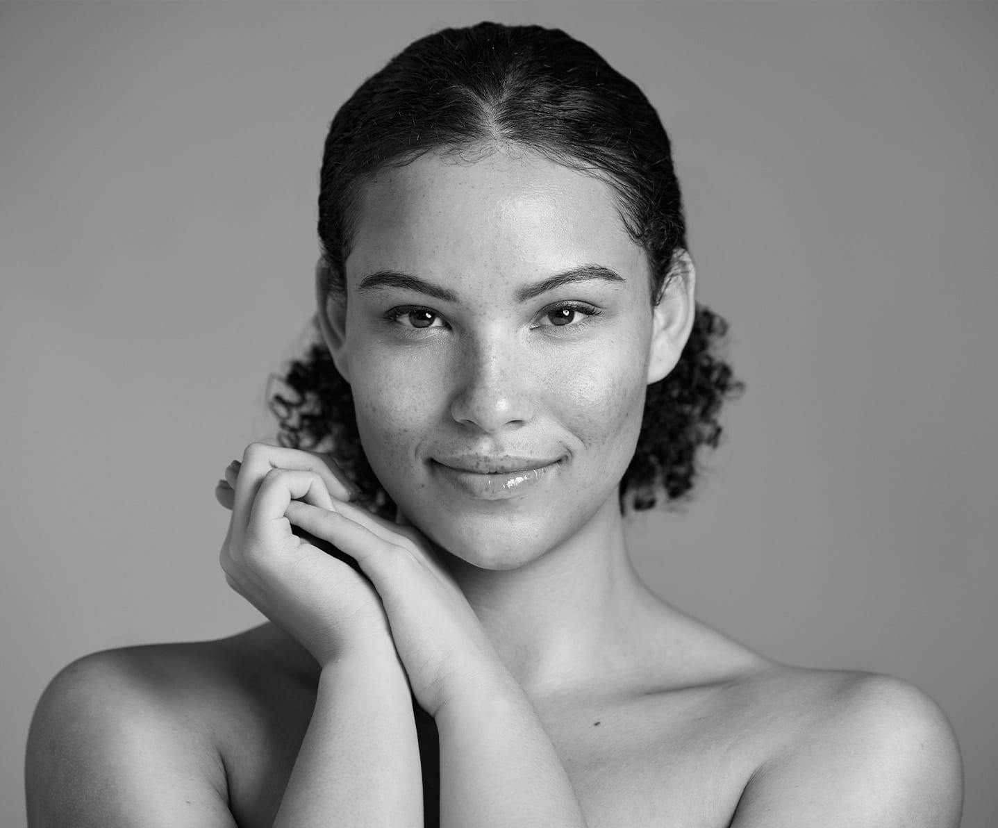 woman clasping hands and smiling at camera