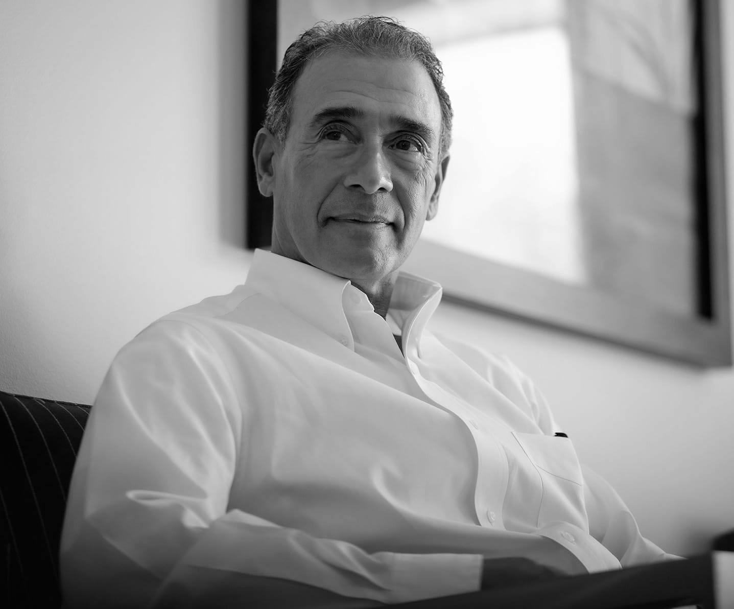 man dressed in a white collared shirt sitting in a shirt