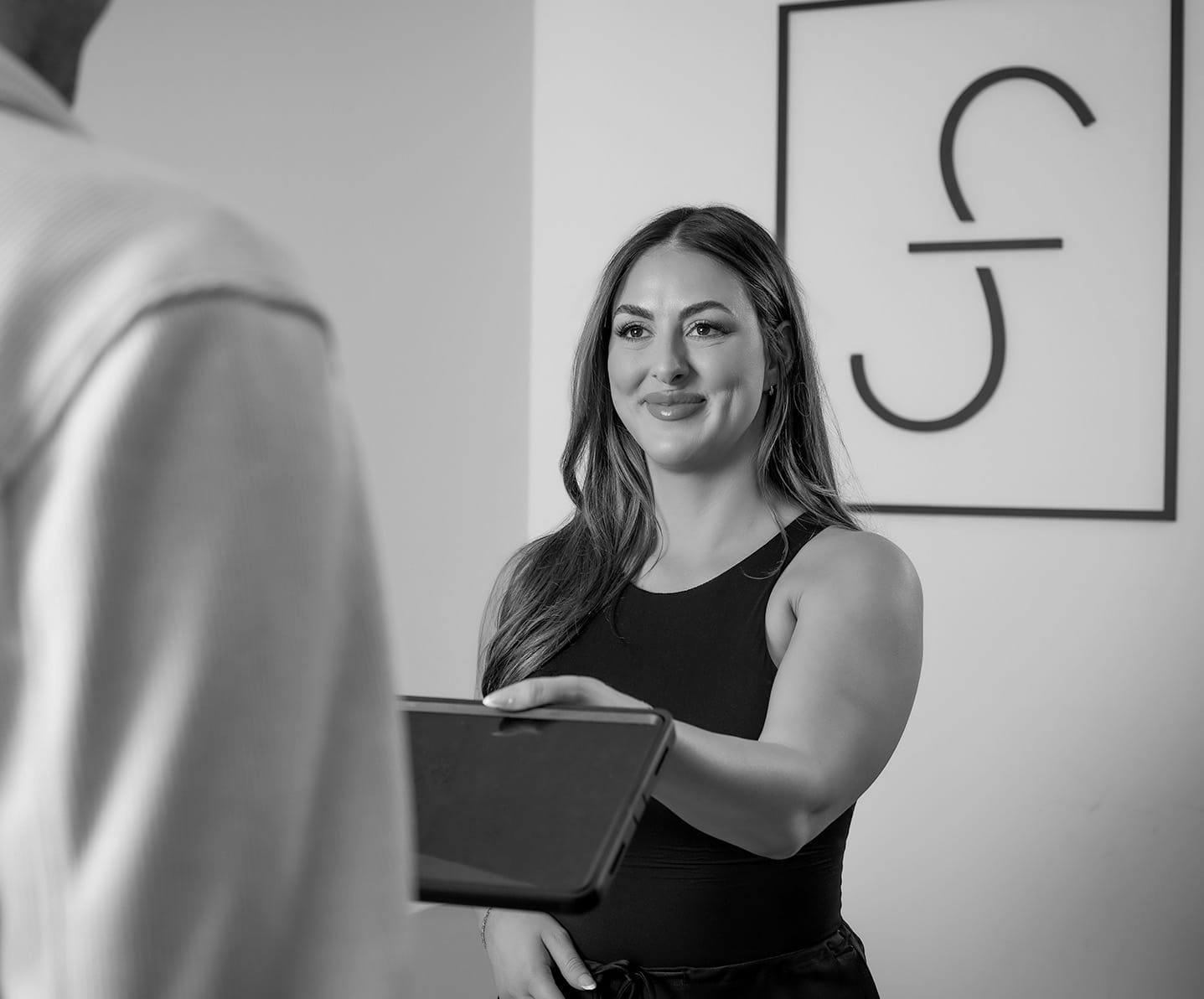 woman handing a tablet to a man