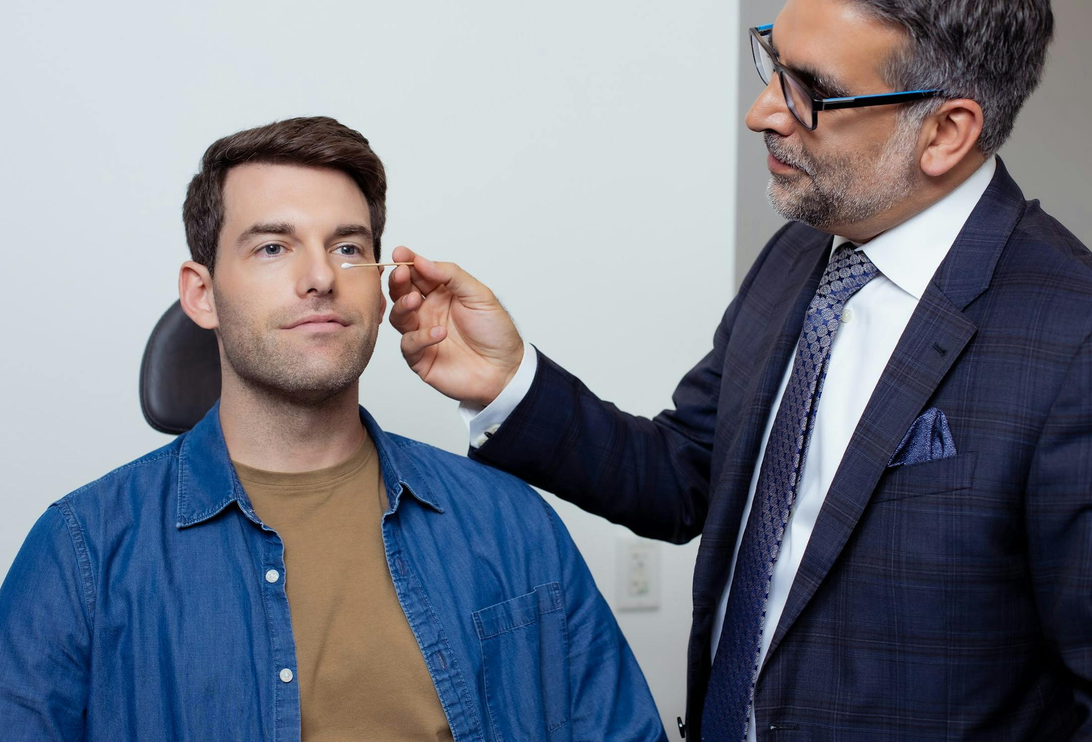 doctor touching patients face with qu-tip