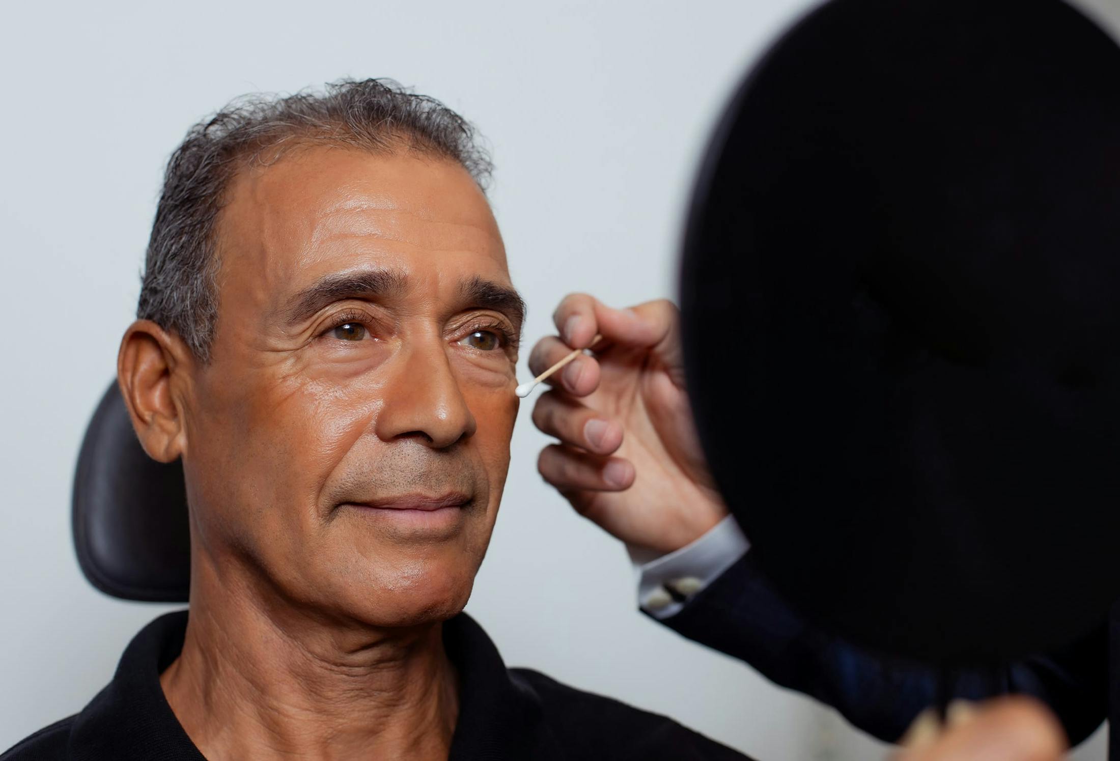 doctor putting a q-tip to a patients face