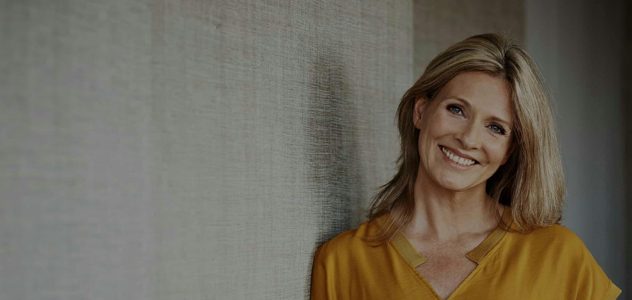 woman in a yellow shirt smiling