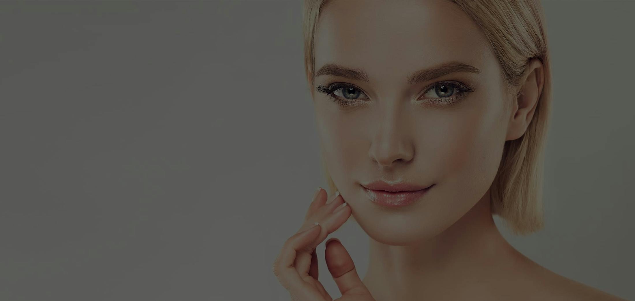 Pretty blonde woman with hand on her face near her mouth