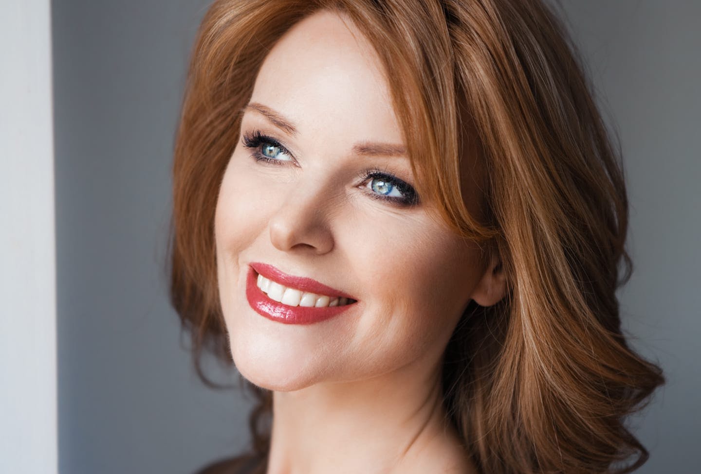 Up close of model smiling while looking out window