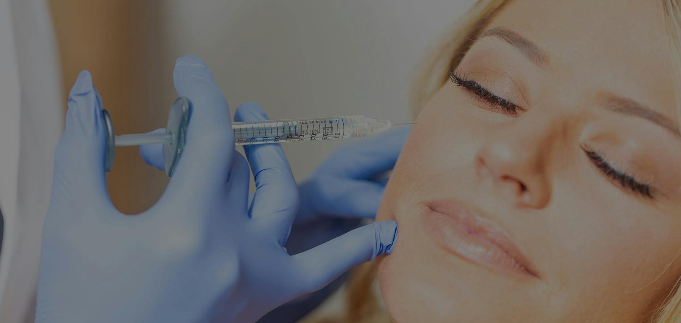 Woman recieving cosmetic injections in her cheek area