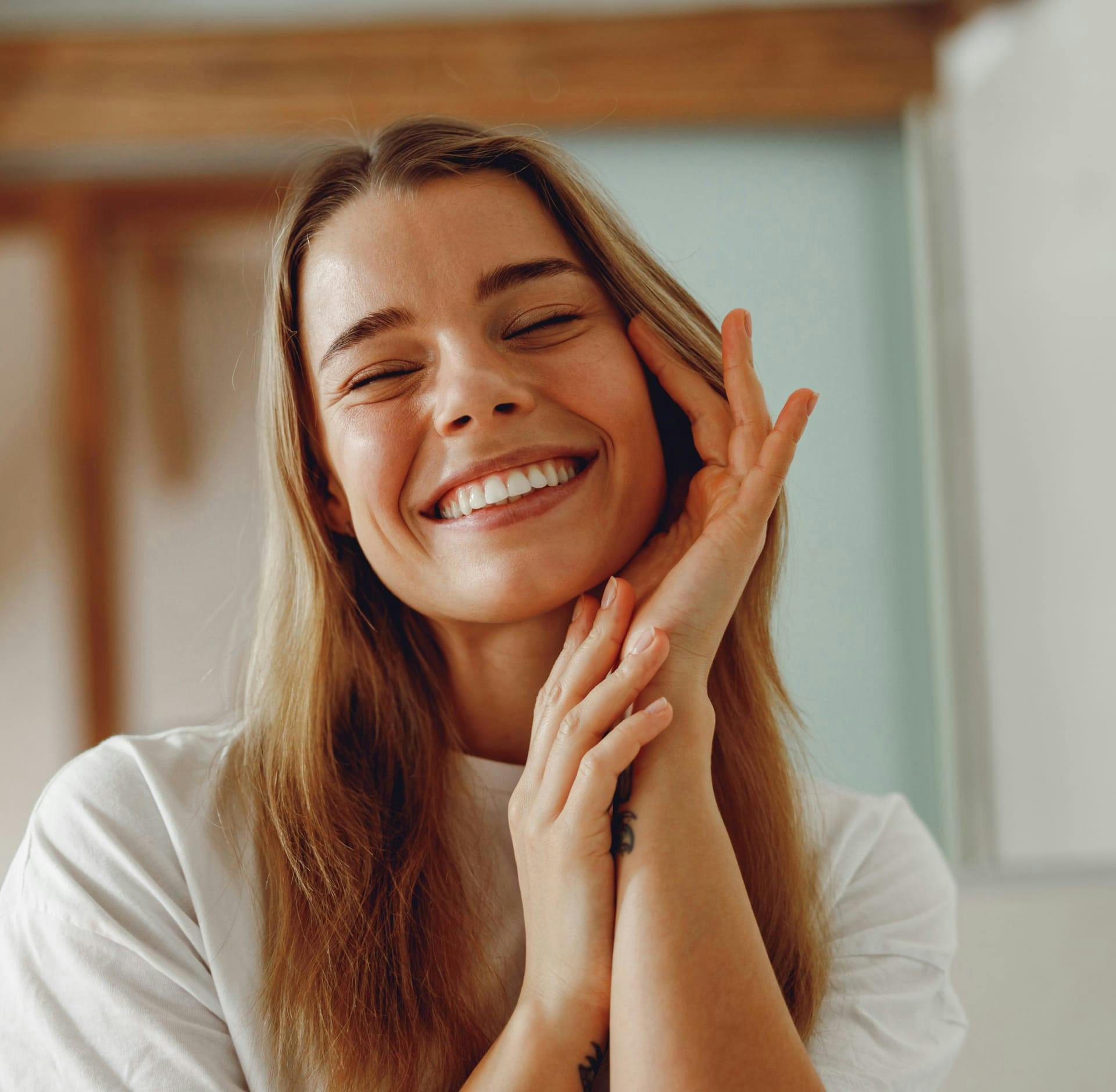 Woman smiling holding side of face