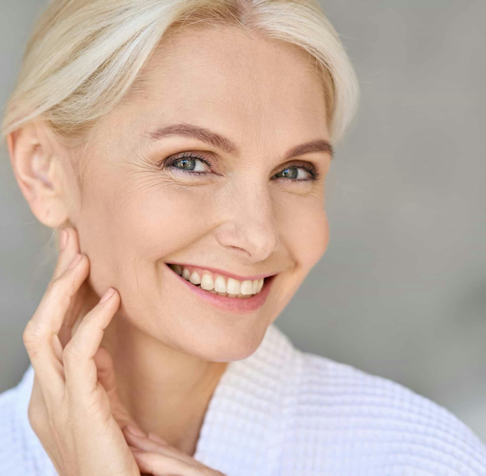 Woman smiling and touching face