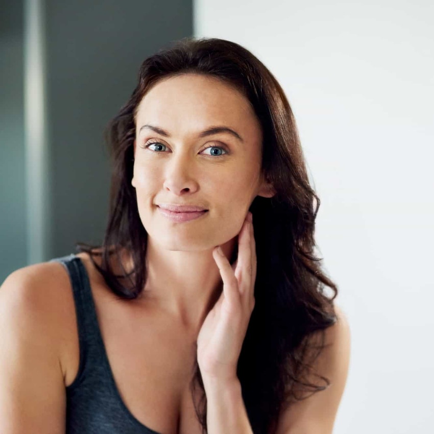 Woman smiling and touching face