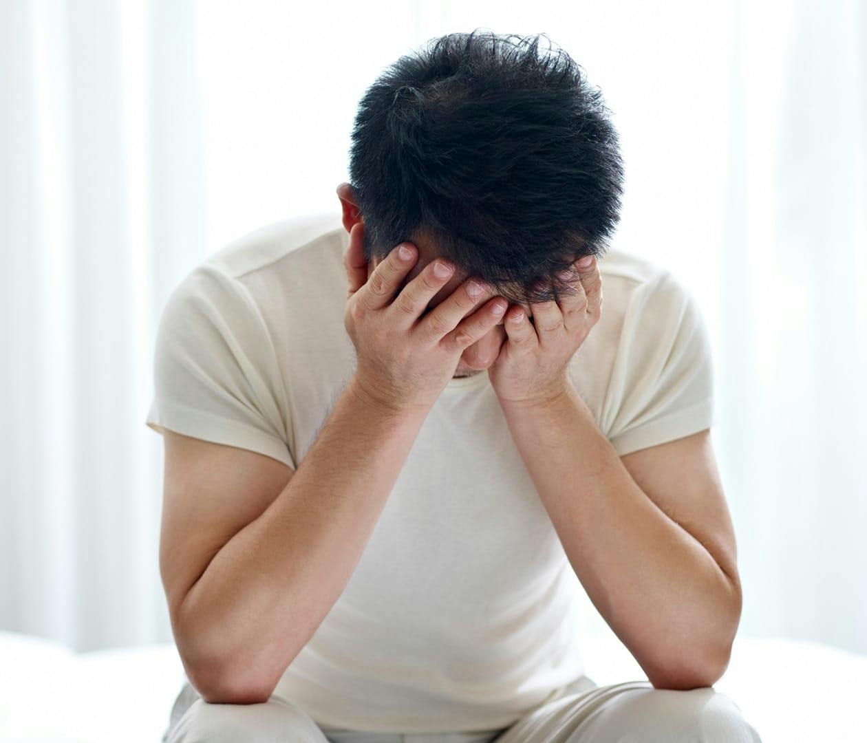 man resting his head in both of his hands