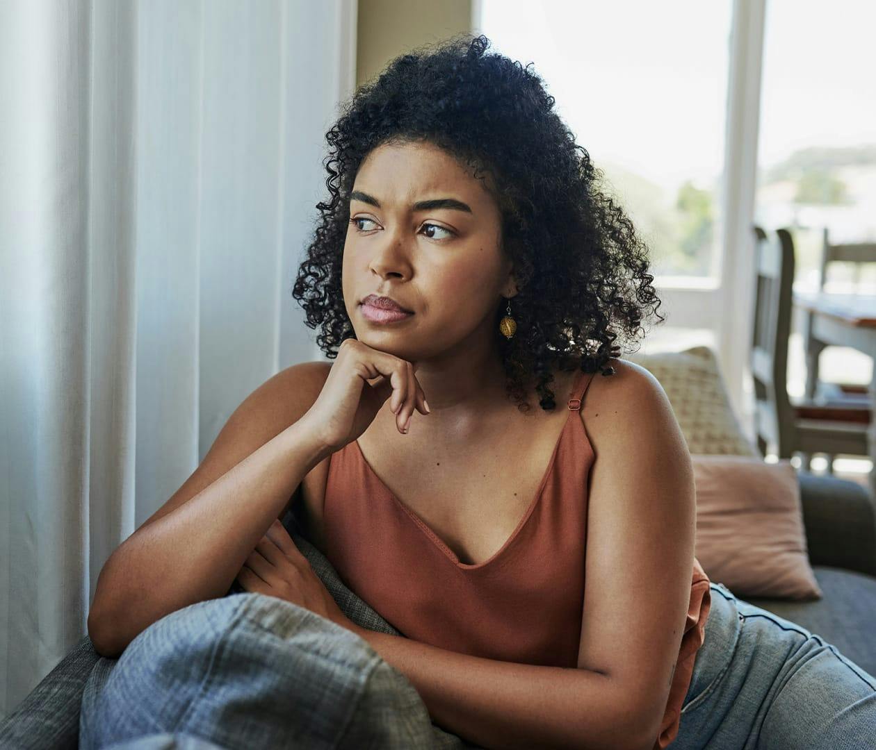 woman sitting on couch looking concerned