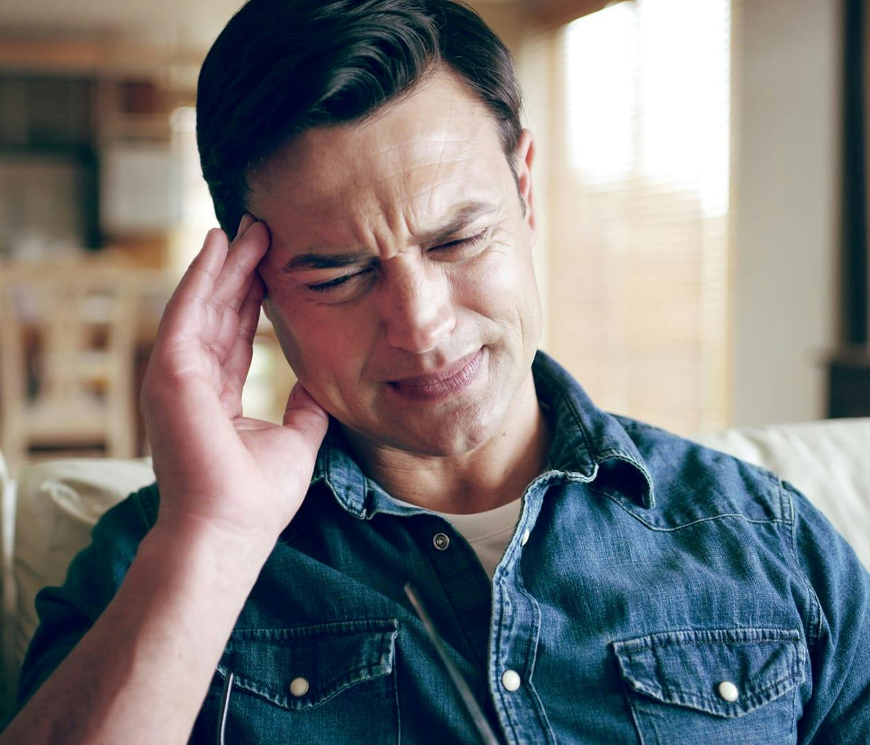 man with a headache rubbing his temple