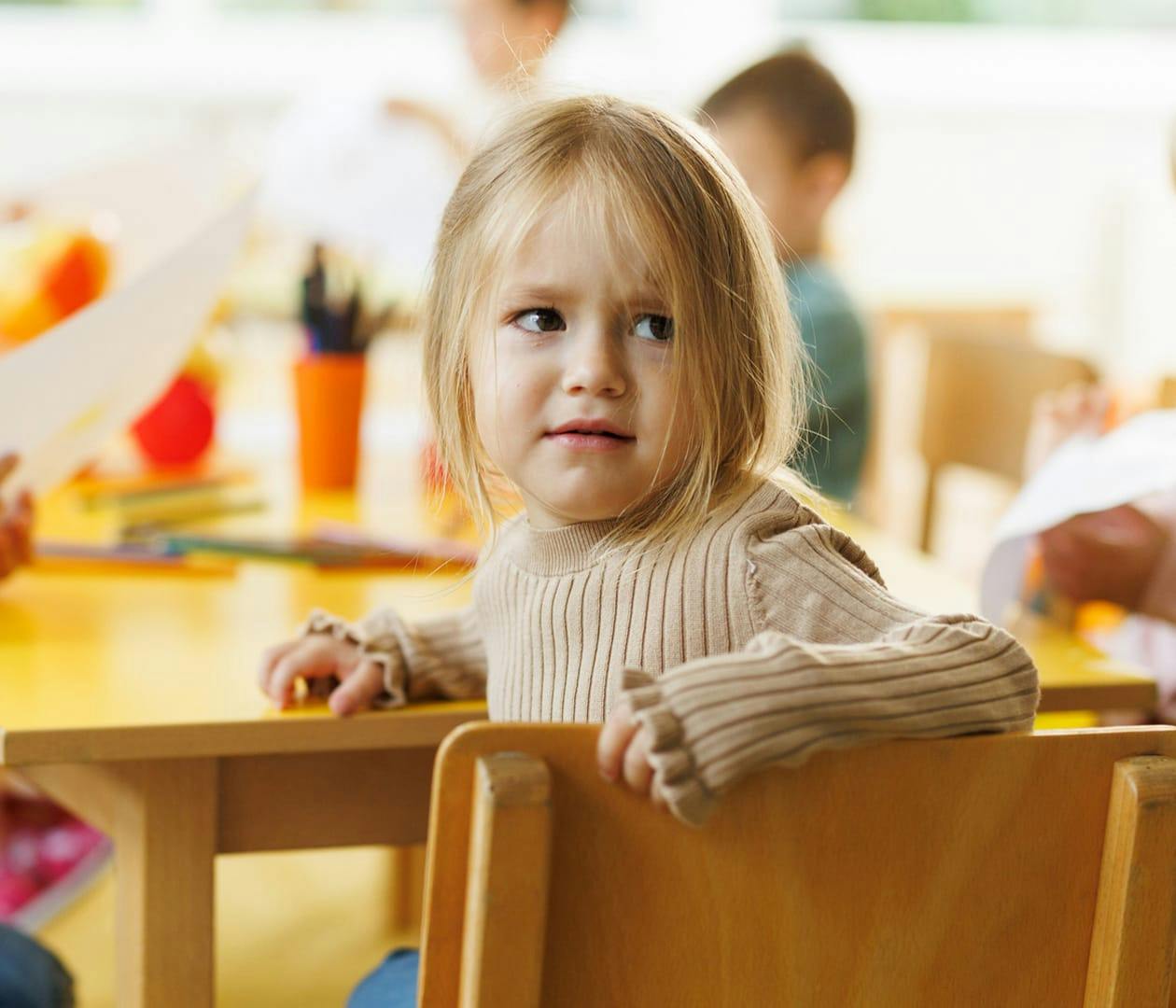 toddler sitting in chair looking upset