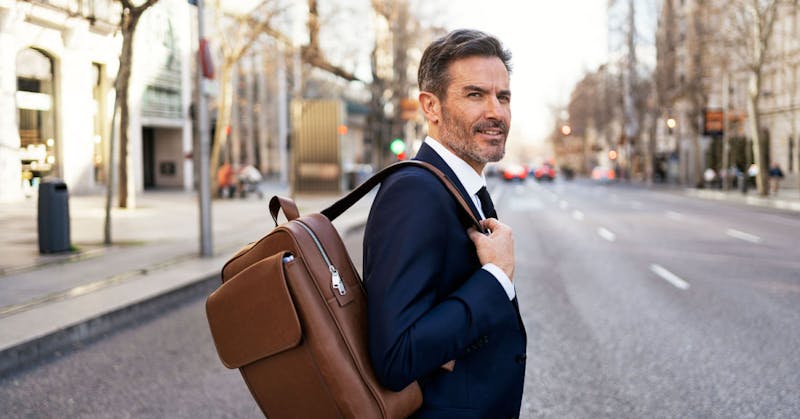 A man holding a brown bag walking