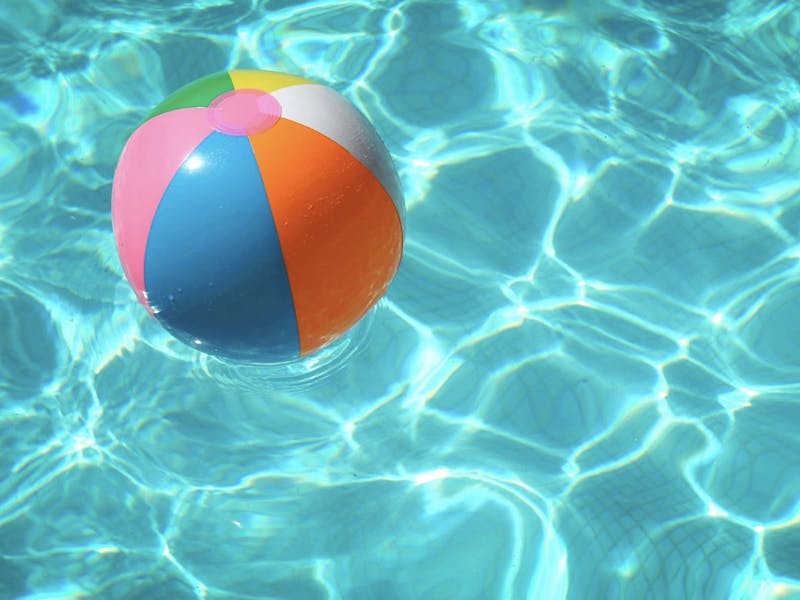 A rainbow ball floating in a pool
