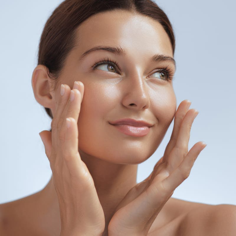 Woman smiling and touching face